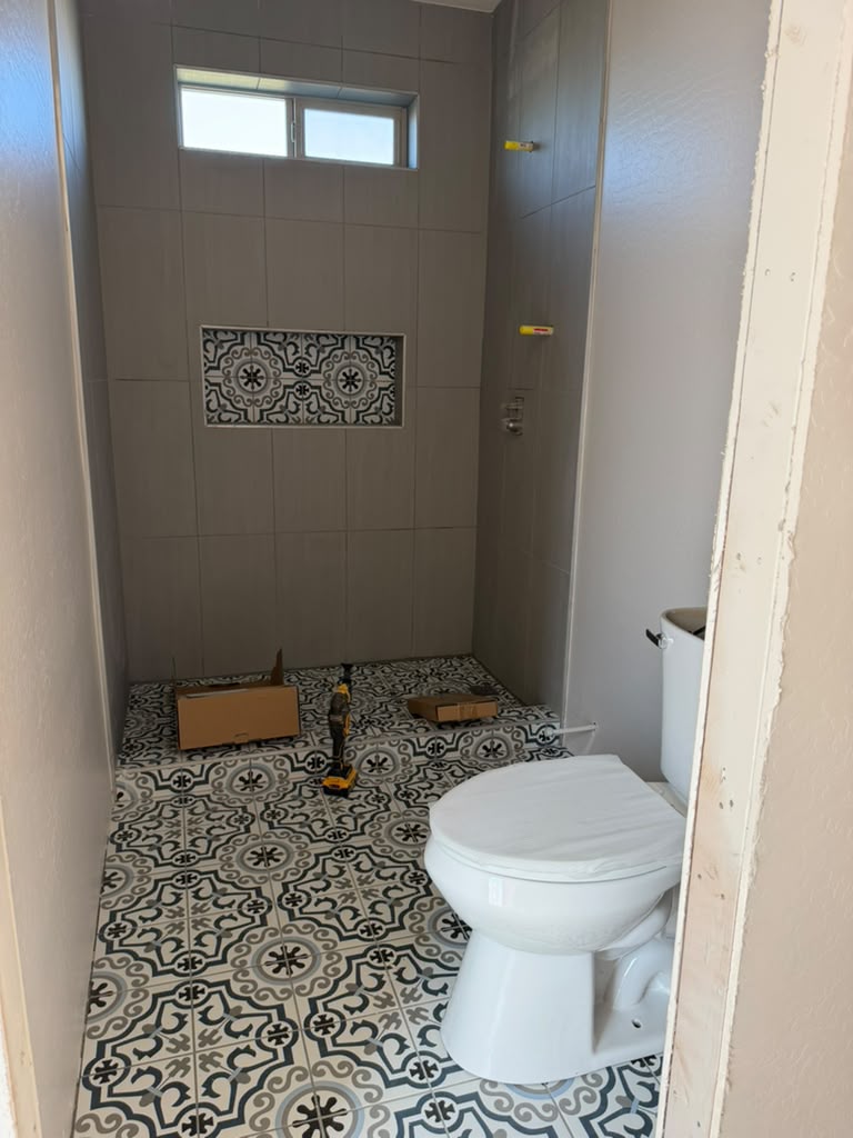 Baño del Pool Lounge 325 con piso de azulejo de patrón y regadera con nicho