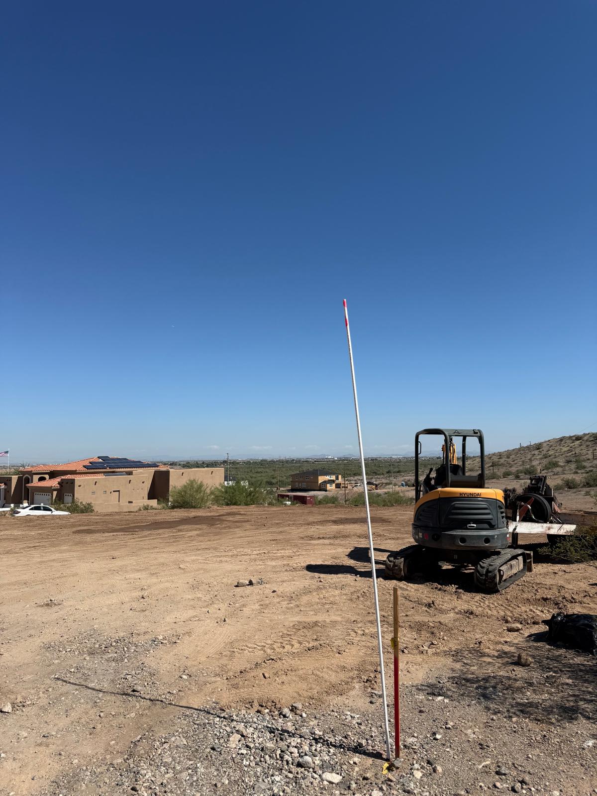 Excavadora y marcador de nivel en el terreno de la Residencia Mediterráneo 5319 sq ft en Goodyear
