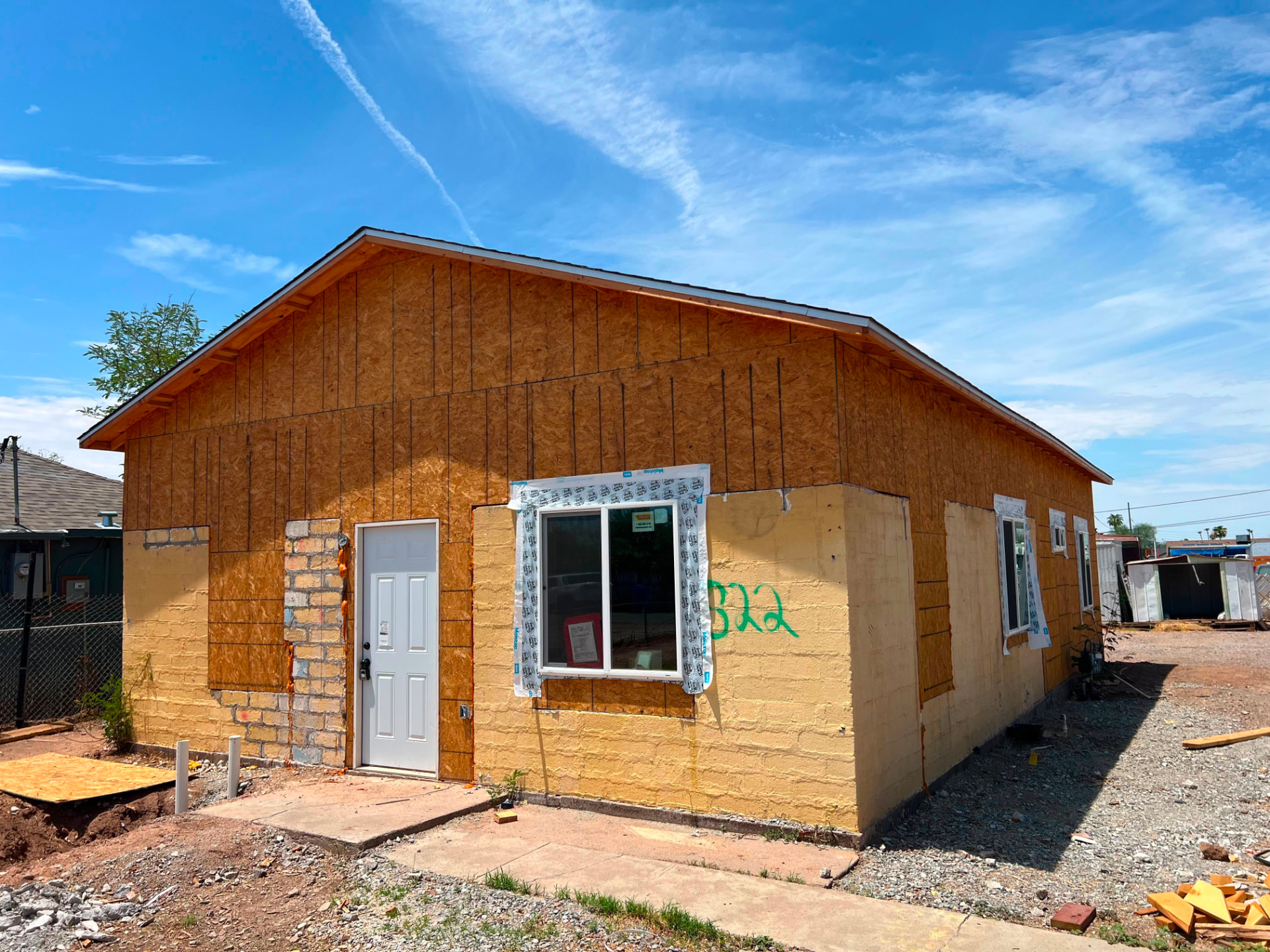 Fachada frontal con forro OSB, puerta y ventana instaladas — Main House 1300 sq ft