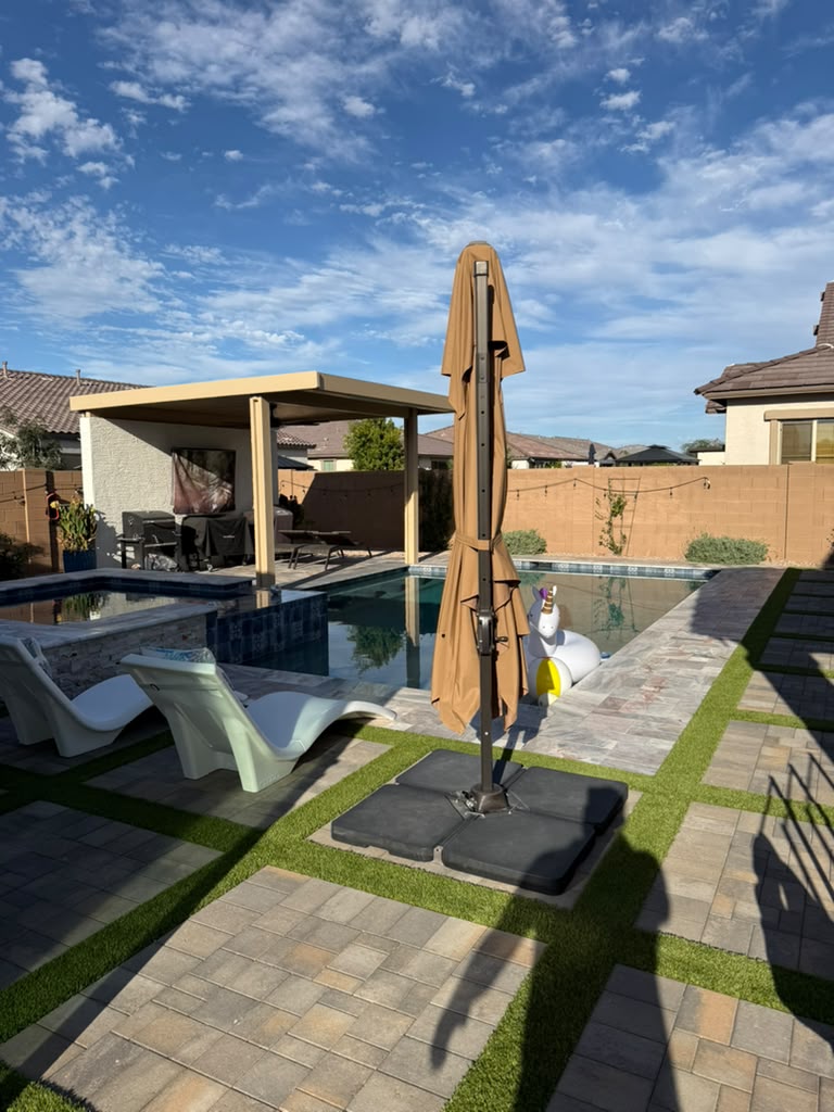 Patio trasero de Queen Creek con alberca, pérgola y andadores de adoquín