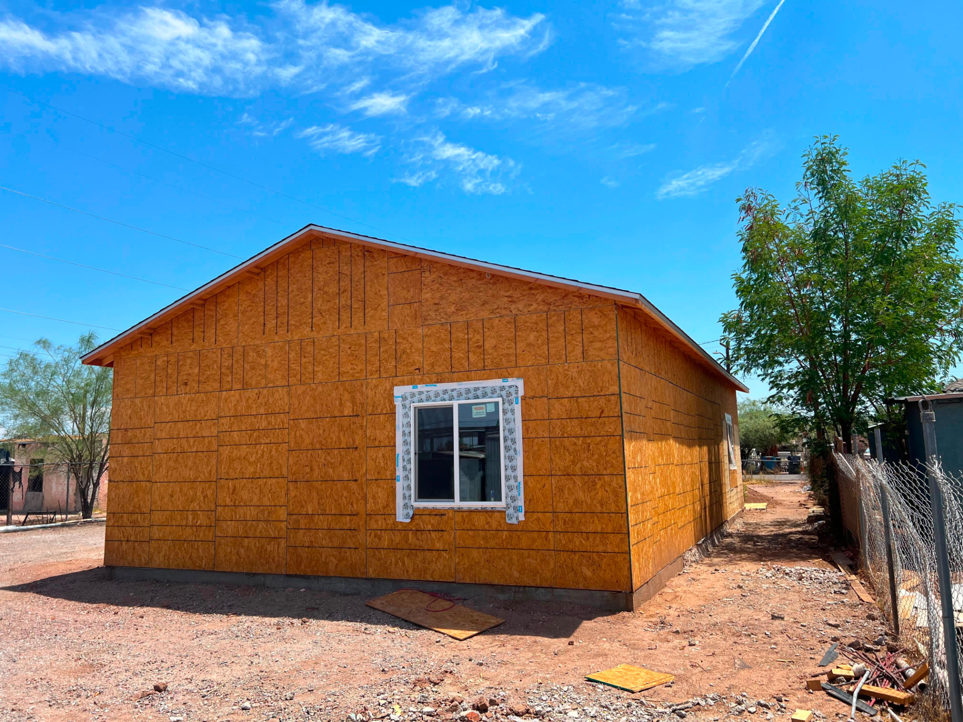 Vista lateral con forro OSB completo y ventana nueva — Main House 1300 sq ft