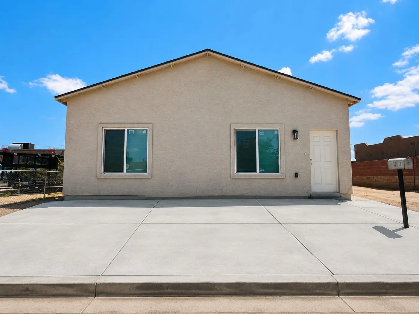 Vista frontal del duplex con stucco beige y entrada lateral