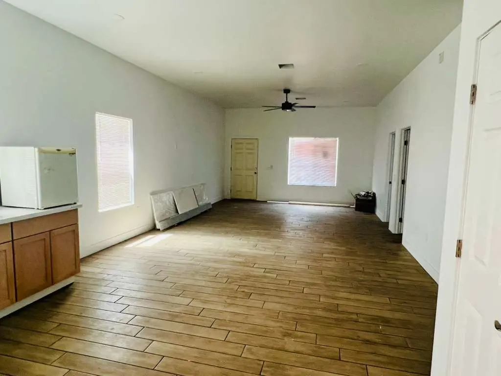 Sala/comedor amplio con piso tipo madera y ventilador de techo