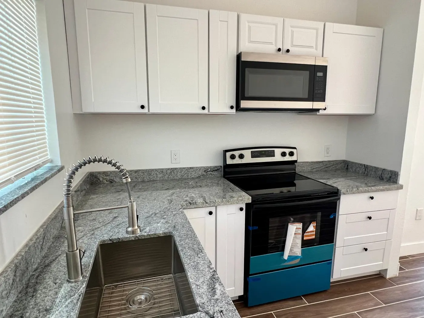 Cocina con granito y gabinetes blancos