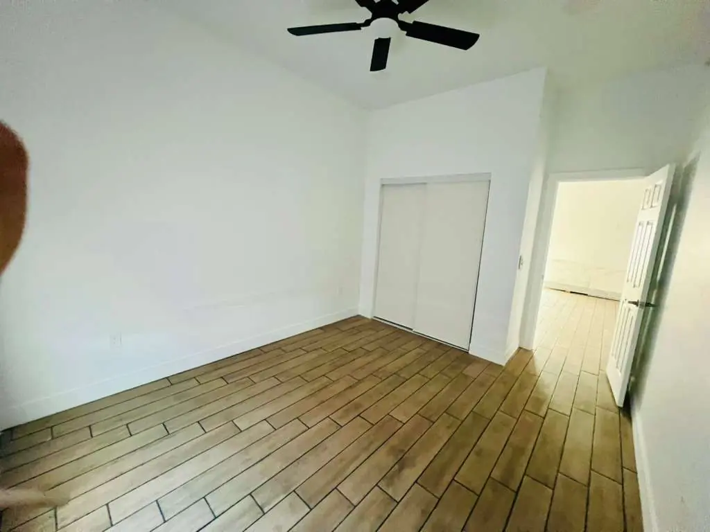 Recámara con clóset empotrado de puertas corredizas y ventilador de techo