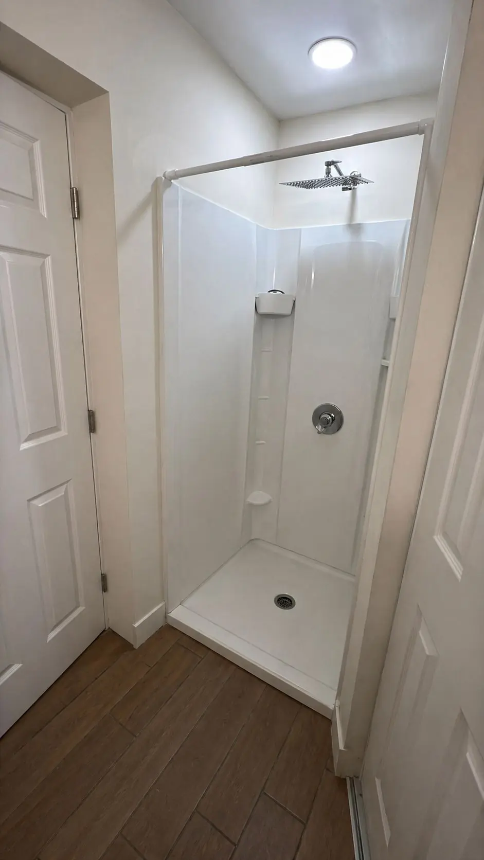 Baño con ducha de lluvia y acabados blancos