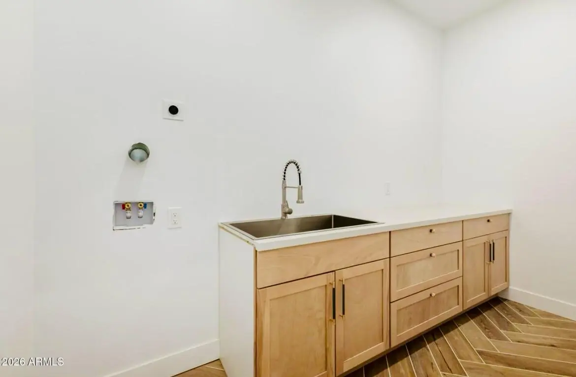 Cuarto de lavandería con gabinetes y fregadero