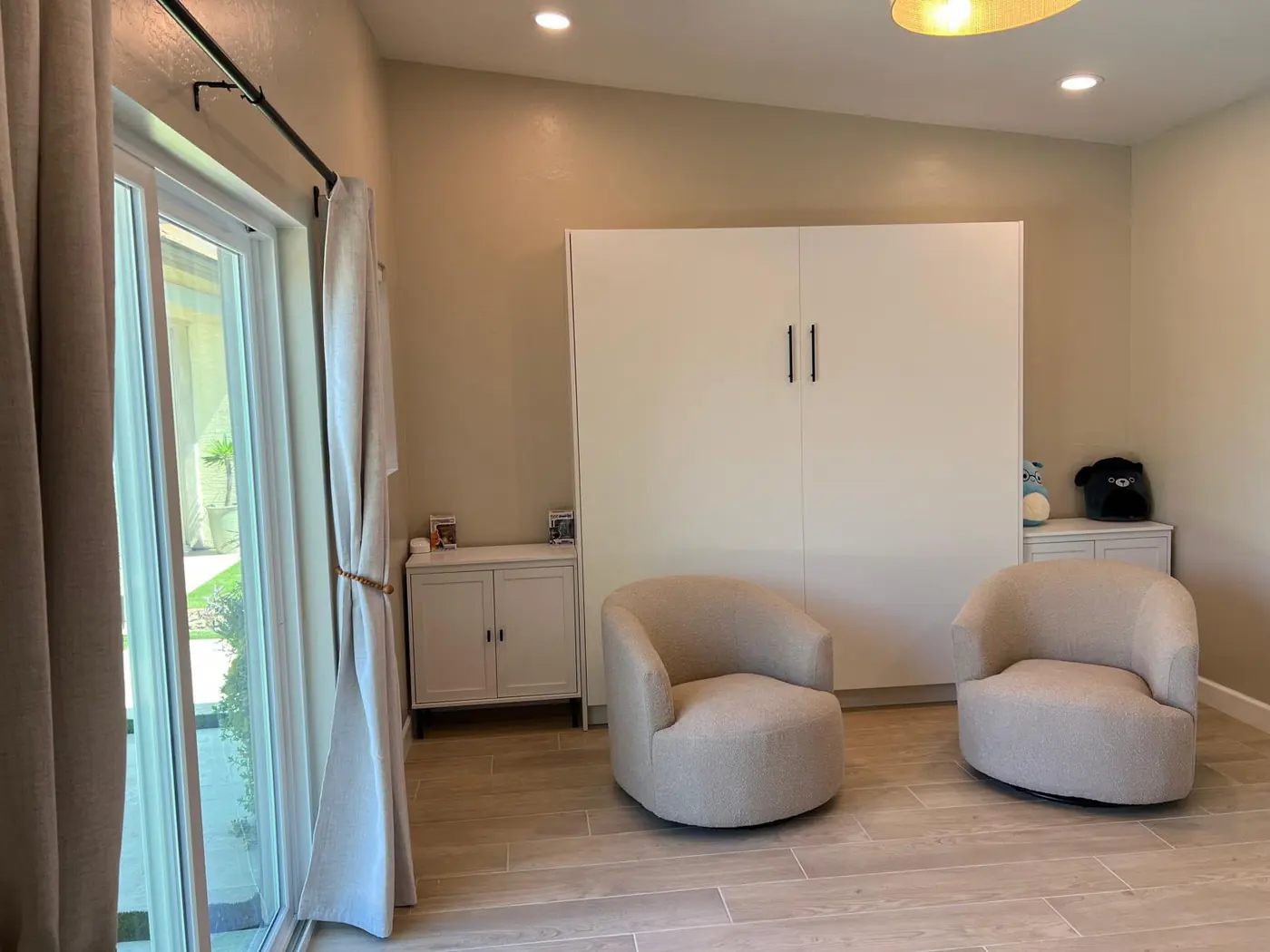Sala interior con cama Murphy, sillones y acceso al patio